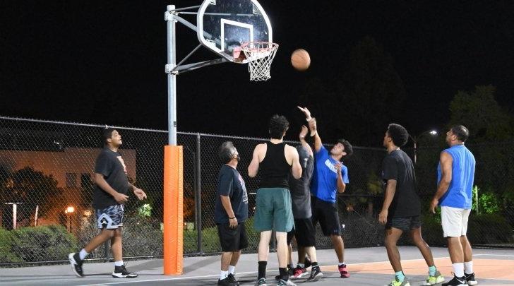 Students play a pickup game of basketball outside McConnell Center